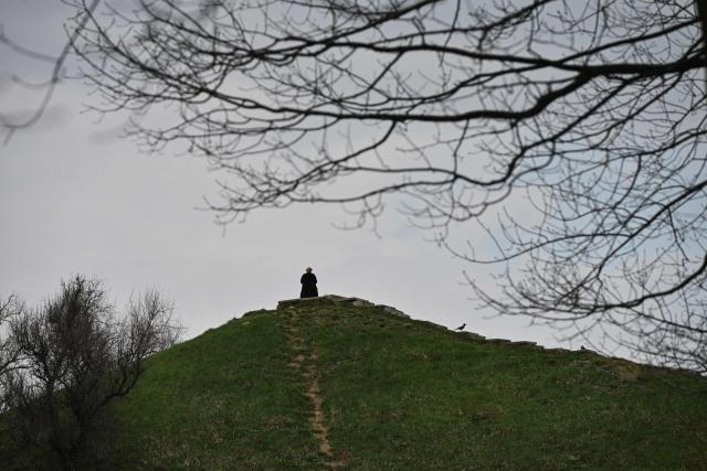 A person walks through the Gryshko National Botanical Garden in Kyiv on April 1, 2026, amid the Russian invasion of Ukraine. (Photo by Genya SAVILOV / AFP)