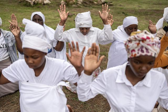 Congregants gesture during an open-air service held by the Johani Masowe of Baba Emmanuel church near Randfontein on April 1, 2026. (Photo by EMMANUEL CROSET / AFP)