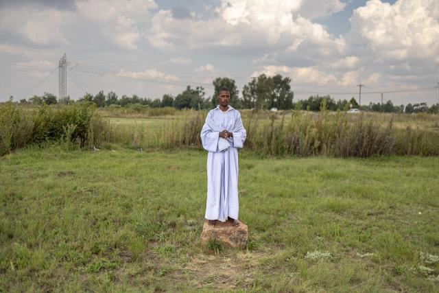 A congregant poses for a portrait after an open-air service held by the Johani Masowe of Baba Emmanuel church near Randfontein on April 1, 2026. (Photo by EMMANUEL CROSET / AFP)