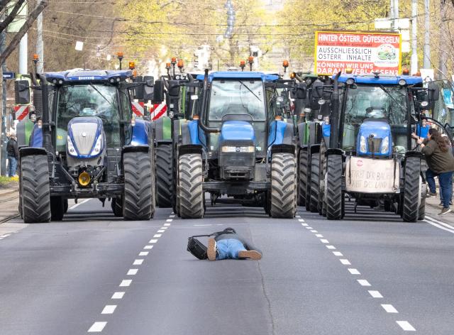 A man takes a picture of a convoy of tractors during a framer's protest in Vienna on April 1, 2026. A convoy of 300 tractors rolled through Vienna urging restaurants and supermarkets to label the origin of ingredients. (Photo by Joe Klamar / AFP)
