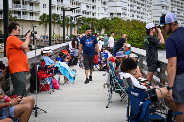 Space enthusiasts gather at a park in Titusville, Florida several hours before NASA's Artemis II Space Launch System (SLS) rocket is scheduled to launch from the Kennedy Space Center on April 1, 2026. On Wednesday three men and one woman are set to embark on the first crewed journey to the Moon since 1972, a landmark odyssey that aims to launch the US into a new era of space exploration. The NASA mission dubbed Artemis 2 has been years in the making after facing repeated setbacks, but is finally scheduled to take off from Florida as early as April 1 at 6:24 pm (2224 GMT). (Photo by Miguel J Rodriguez Carrillo / AFP)