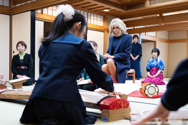 French first lady Brigitte Macron meets Japanese traditional music students playing koto at Harumi Comprehensive High School in Tokyo on April 1, 2026. (Photo by Jeanne Accorsini / POOL / AFP)