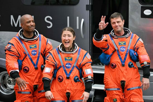 (L/R)  NASA astronauts Victor Glover, Artemis II pilot, Christina Koch, Artemis II mission specialist, and Reid Wiseman, Artemis II commander, walk out before boarding a bus to travel to the launch pad to board the Artemis II crewed lunar mission at Kennedy Space Center in Cape Canaveral, Florida, on April 1, 2026. On Wednesday three men and one woman are set to embark on the first crewed journey to the Moon since 1972, a landmark odyssey that aims to launch the US into a new era of space exploration. The NASA mission dubbed Artemis 2 has been years in the making after facing repeated setbacks, but is finally scheduled to take off from Florida as early as April 1 at 6:24 pm (2224 GMT). (Photo by Jim WATSON / AFP)