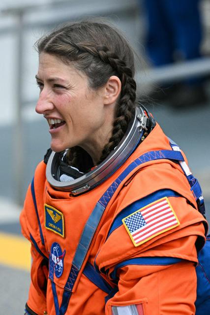 NASA astronaut Christina Koch, Artemis II mission specialist, smiles as she walks out before boarding a bus to travel to the launch pad to board the Space Launch System (SLS) rocket for the Artemis II crewed lunar mission at Kennedy Space Center in Cape Canaveral, Florida, on April 1, 2026. On Wednesday three men and one woman are set to embark on the first crewed journey to the Moon since 1972, a landmark odyssey that aims to launch the US into a new era of space exploration. The NASA mission dubbed Artemis 2 has been years in the making after facing repeated setbacks, but is finally scheduled to take off from Florida as early as April 1 at 6:24 pm (2224 GMT). (Photo by Jim WATSON / AFP)
