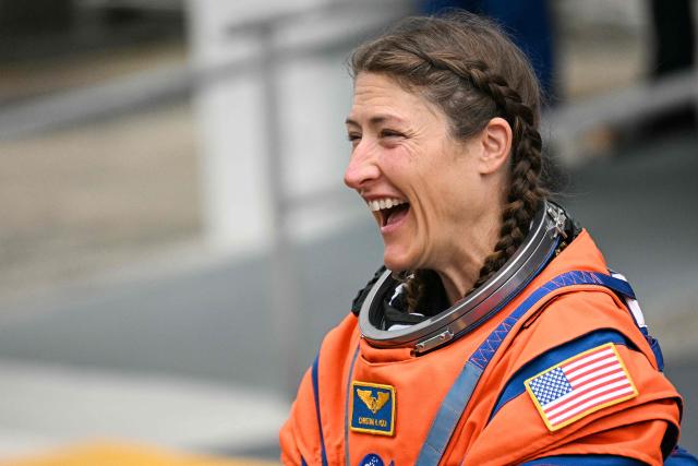 NASA astronaut Christina Koch, Artemis II mission specialist, smiles as she walks out before boarding a bus to travel to the launch pad to board the Space Launch System (SLS) rocket for the Artemis II crewed lunar mission at Kennedy Space Center in Cape Canaveral, Florida, on April 1, 2026. On Wednesday three men and one woman are set to embark on the first crewed journey to the Moon since 1972, a landmark odyssey that aims to launch the US into a new era of space exploration. The NASA mission dubbed Artemis 2 has been years in the making after facing repeated setbacks, but is finally scheduled to take off from Florida as early as April 1 at 6:24 pm (2224 GMT). (Photo by Jim WATSON / AFP)
