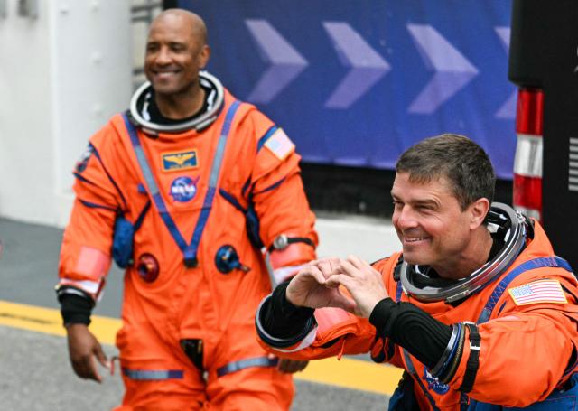 (L/R) NASA astronauts Victor Glover, Artemis II pilot, and Reid Wiseman, Artemis II commander, walk out before traveling to the launch pad to board the Space Launch System (SLS) rocket for the Artemis II crewed lunar mission at Kennedy Space Center in Cape Canaveral, Florida, on April 1, 2026. On Wednesday three men and one woman are set to embark on the first crewed journey to the Moon since 1972, a landmark odyssey that aims to launch the US into a new era of space exploration. The NASA mission dubbed Artemis 2 has been years in the making after facing repeated setbacks, but is finally scheduled to take off from Florida as early as April 1 at 6:24 pm (2224 GMT). (Photo by Jim WATSON / AFP)