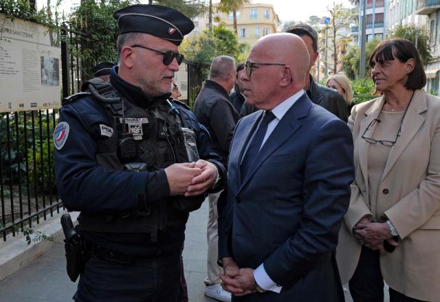 Union des droites pour la Republique (UDR) leader and newly elected Nice mayor Eric Ciotti (C) speaks to a police officer as he visits the Rue Trachel neighborhood during a police operation to combat drug trafficking, in Nice souteastern France, on April 1, 2026. (Photo by Valery HACHE / AFP)