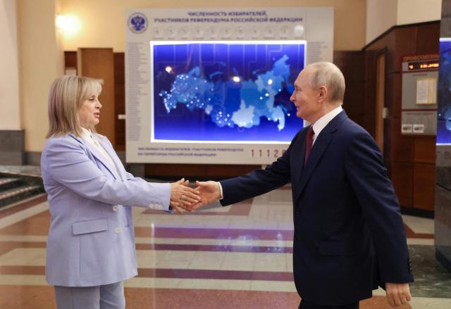 This pool photograph distributed by the Russian state agency Sputnik, shows Russia's President Vladimir Putin (R) handshakes with chairperson of the Central Election Comission Ella Pamfilova (L) during his meeting with the new members of the Central Election Comission in Moscow on April 1, 2026. (Photo by Viacheslav PROKOFIEV / POOL / AFP)