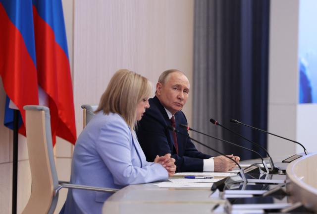 This pool photograph distributed by the Russian state agency Sputnik, shows Russia's President Vladimir Putin (R) and the chairperson of the Central Election Comission Ella Pamfilova (L) during a meeting with the new members of the Central Election Comission in Moscow on April 1, 2026. (Photo by Viacheslav PROKOFIEV / POOL / AFP)