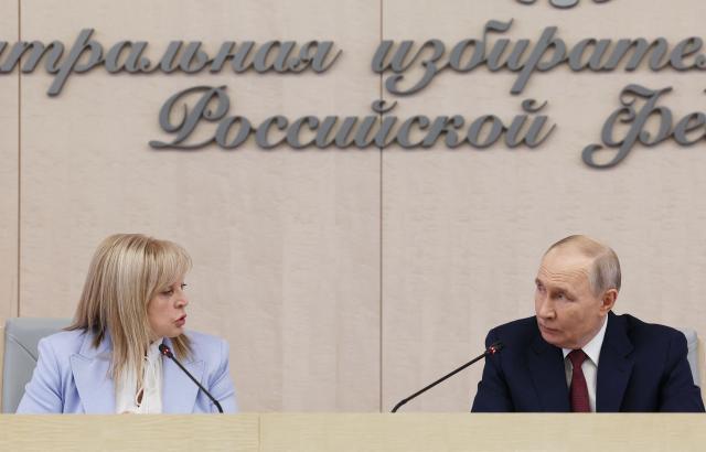 This pool photograph distributed by the Russian state agency Sputnik, shows Russia's President Vladimir Putin (R) and the chairperson of the Central Election Comission Ella Pamfilova (L) during a meeting with the new members of the Central Election Comission in Moscow on April 1, 2026. (Photo by Viacheslav PROKOFIEV / POOL / AFP)