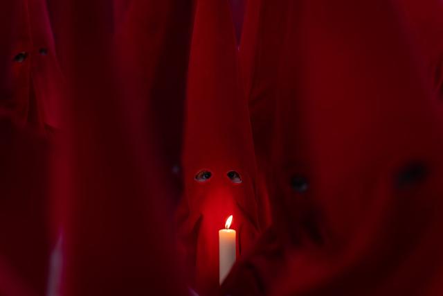 TOPSHOT - Members of the "Real Hermandad del Santisimo Cristo de las Injurias" brotherhood hold candles outside the cathedral while taking a vow of silence prior to the Holy Wednesday Silence Procession in Zamora, northwestern Spain, on April 1, 2026. Spain's colourful Holy Week celebrations started this week, featuring centuries-old processions of the faithful carrying flower-covered floats topped with statues of Christ or the Virgin Mary that draw huge crowds. Organised by various religious brotherhoods, or "confradias", the parades are held across the country in the week leading up to Easter Sunday, which this year in the Roman Catholic Church falls on April 5, 2026. (Photo by CESAR MANSO / AFP)