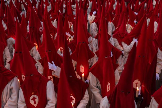 Members of the "Real Hermandad del Santisimo Cristo de las Injurias" brotherhood hold candles outside the cathedral while taking a vow of silence prior to the Holy Wednesday Silence Procession in Zamora, northwestern Spain, on April 1, 2026. Spain's colourful Holy Week celebrations started this week, featuring centuries-old processions of the faithful carrying flower-covered floats topped with statues of Christ or the Virgin Mary that draw huge crowds. Organised by various religious brotherhoods, or "confradias", the parades are held across the country in the week leading up to Easter Sunday, which this year in the Roman Catholic Church falls on April 5, 2026. (Photo by CESAR MANSO / AFP)