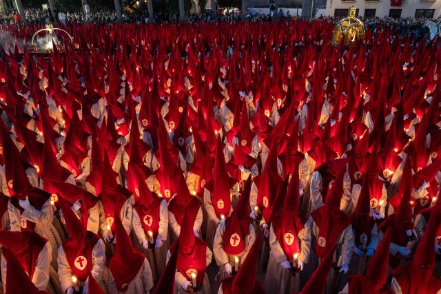 TOPSHOT - Members of the "Real Hermandad del Santisimo Cristo de las Injurias" brotherhood hold candles outside the cathedral while taking a vow of silence prior to the Holy Wednesday Silence Procession in Zamora, northwestern Spain, on April 1, 2026. Spain's colourful Holy Week celebrations started this week, featuring centuries-old processions of the faithful carrying flower-covered floats topped with statues of Christ or the Virgin Mary that draw huge crowds. Organised by various religious brotherhoods, or "confradias", the parades are held across the country in the week leading up to Easter Sunday, which this year in the Roman Catholic Church falls on April 5, 2026. (Photo by CESAR MANSO / AFP)