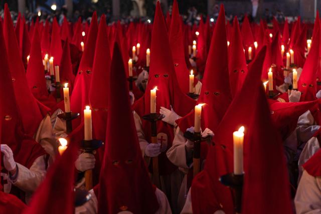 Members of the "Real Hermandad del Santisimo Cristo de las Injurias" brotherhood hold candles outside the cathedral while taking a vow of silence prior to the Holy Wednesday Silence Procession in Zamora, northwestern Spain, on April 1, 2026. Spain's colourful Holy Week celebrations started this week, featuring centuries-old processions of the faithful carrying flower-covered floats topped with statues of Christ or the Virgin Mary that draw huge crowds. Organised by various religious brotherhoods, or "confradias", the parades are held across the country in the week leading up to Easter Sunday, which this year in the Roman Catholic Church falls on April 5, 2026. (Photo by CESAR MANSO / AFP)