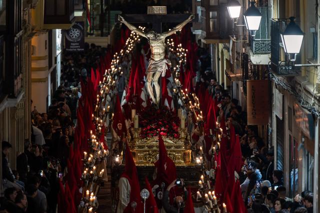 Members of the "Real Hermandad del Santisimo Cristo de las Injurias" brotherhood carry a float with a statue of Christ during the Holy Wednesday Silence Procession in Zamora, northwestern Spain, on April 1, 2026. Spain's colourful Holy Week celebrations started this week, featuring centuries-old processions of the faithful carrying flower-covered floats topped with statues of Christ or the Virgin Mary that draw huge crowds. Organised by various religious brotherhoods, or "confradias", the parades are held across the country in the week leading up to Easter Sunday, which this year in the Roman Catholic Church falls on April 5, 2026. (Photo by CESAR MANSO / AFP)