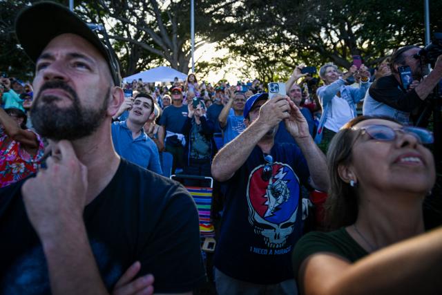 Space enthusiasts at a park in Titusville, view the Artemis II crewed lunar mission lift off from Pad 39B at Kennedy Space Center in Cape Canaveral, Florida, on April 1, 2026. Four astronauts blasted off aboard a massive NASA rocket April 1 on a long-anticipated journey around the Moon, the first crewed lunar flyby in more than 50 years. With an intense roar that reverberated far beyond the launchpad, the enormous orange-and-white rocket carried three Americans and one Canadian away from Florida's Kennedy Space Center at approximately 6:35 pm local time, according to an AFP journalist onsite. "We're going to the Moon!" yelled a spectator. (Photo by Miguel J Rodriguez Carrillo / AFP)