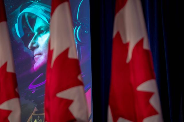An image of Canadian Space Agency (CSA) astronaut Jeremy Hansen is seen during a viewing party of the Artemis II launch, in Longueuil, near Montreal, Quebec, on April 1, 2026. Four astronauts blasted off aboard a massive NASA rocket April 1 on a long-anticipated journey around the Moon, the first crewed lunar flyby in more than 50 years. With an intense roar that reverberated far beyond the launchpad, the enormous orange-and-white rocket carried three Americans and one Canadian away from Florida's Kennedy Space Center at approximately 6:35 pm local time, according to an AFP journalist onsite. "We're going to the Moon!" yelled a spectator. (Photo by ANDREJ IVANOV / AFP)