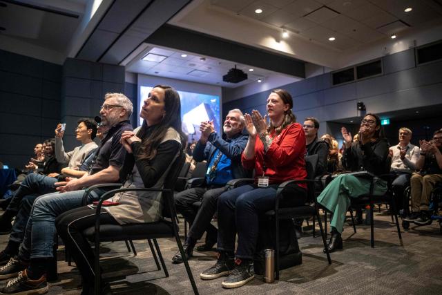 People react while watching the live broadcast of the Artemis II lunar mission launch, with Canadian Space Agency (CSA) astronaut Jeremy Hansen on board, during a viewing party at the CSA offices in Longueuil, near Montreal, Quebec, on April 1, 2026. Four astronauts blasted off aboard a massive NASA rocket April 1 on a long-anticipated journey around the Moon, the first crewed lunar flyby in more than 50 years. With an intense roar that reverberated far beyond the launchpad, the enormous orange-and-white rocket carried three Americans and one Canadian away from Florida's Kennedy Space Center at approximately 6:35 pm local time, according to an AFP journalist onsite. "We're going to the Moon!" yelled a spectator. (Photo by ANDREJ IVANOV / AFP)