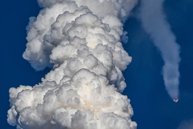 The solid rocket boosters are seen as they fall away after separating from NASAs Space Launch System (SLS) rocket shortly after the Artemis II crewed lunar mission lift off from Pad 39B at Kennedy Space Center in Cape Canaveral, Florida, on April 1, 2026. Four astronauts blasted off aboard a massive NASA rocket April 1 on a long-anticipated journey around the Moon, the first crewed lunar flyby in more than 50 years. With an intense roar that reverberated far beyond the launchpad, the enormous orange-and-white rocket carried three Americans and one Canadian away from Florida's Kennedy Space Center at approximately 6:35 pm local time, according to an AFP journalist onsite. "We're going to the Moon!" yelled a spectator. (Photo by Miguel J Rodriguez Carrillo / AFP)