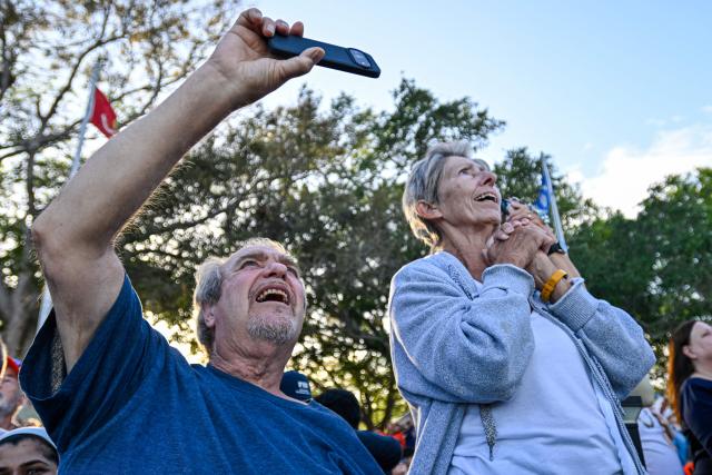 Space enthusiasts at a park in Titusville, view the Artemis II crewed lunar mission lift off from Pad 39B at Kennedy Space Center in Cape Canaveral, Florida, on April 1, 2026. Four astronauts blasted off aboard a massive NASA rocket April 1 on a long-anticipated journey around the Moon, the first crewed lunar flyby in more than 50 years. With an intense roar that reverberated far beyond the launchpad, the enormous orange-and-white rocket carried three Americans and one Canadian away from Florida's Kennedy Space Center at approximately 6:35 pm local time, according to an AFP journalist onsite. "We're going to the Moon!" yelled a spectator. (Photo by Miguel J Rodriguez Carrillo / AFP)