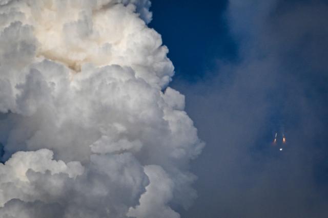 The solid rocket boosters are seen as they fall away after separating from NASAs Space Launch System (SLS) rocket shortly after the Artemis II crewed lunar mission lift off from Pad 39B at Kennedy Space Center in Cape Canaveral, Florida, on April 1, 2026. Four astronauts blasted off aboard a massive NASA rocket April 1 on a long-anticipated journey around the Moon, the first crewed lunar flyby in more than 50 years. With an intense roar that reverberated far beyond the launchpad, the enormous orange-and-white rocket carried three Americans and one Canadian away from Florida's Kennedy Space Center at approximately 6:35 pm local time, according to an AFP journalist onsite. "We're going to the Moon!" yelled a spectator. (Photo by Miguel J Rodriguez Carrillo / AFP)