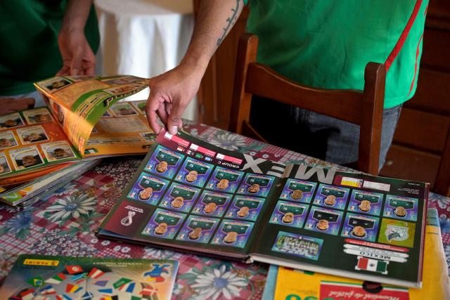 Mexican financial consultant and football fan Jairo Rueda, 31, reviews an album of a football cup during an interview with AFP in Mexico City on March 21, 2026. The Ruedas, Fernando, Jairo and Emilio, are three generations of Mexicans who can no longer afford a World Cup ticket due to the surge in prices compared with the two previous tournaments hosted in the country. (Photo by Alfredo ESTRELLA / AFP)