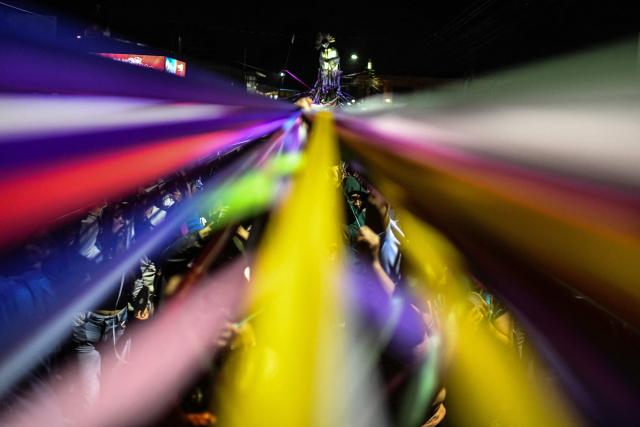 Catholic faithful hold colored tape tied to a statue of Jesus Christ as they take part in a procession known as "Jesus Nazareno of the tapes," during the Holy Week in Cartago, Costa Rica on April 1, 2026. (Photo by Ezequiel BECERRA / AFP)