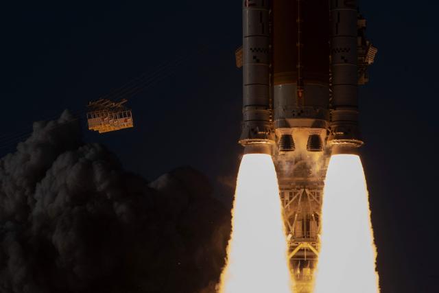 The solid rocket boosters ignite as the Artemis II crewed lunar mission lifts off from Pad 39B at Kennedy Space Center in Cape Canaveral, Florida, on April 1, 2026. Four astronauts blasted off aboard a massive NASA rocket April 1 on a long-anticipated journey around the Moon, the first crewed lunar flyby in more than 50 years. With an intense roar that reverberated far beyond the launchpad, the enormous orange-and-white rocket carried three Americans and one Canadian away from Florida's Kennedy Space Center at approximately 6:35 pm local time, according to an AFP journalist onsite. "We're going to the Moon!" yelled a spectator. (Photo by Jim Watson / AFP)