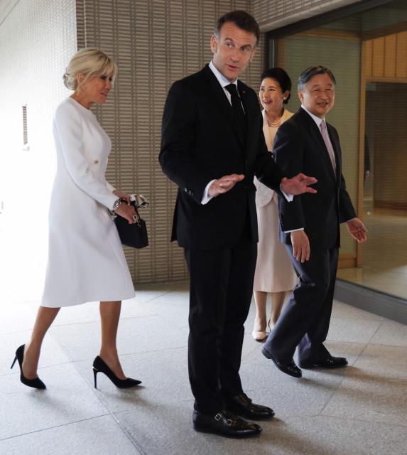 France's President Emmanuel Macron (2nd-L) gestures upon arriving with First Lady Brigitte Macron (L) to meet with Japan's Emperor Naruhito (R) and Empress Masako (L) at the  Imperial Palace in Tokyo on April 2, 2026. (Photo by Ludovic MARIN / POOL / AFP)