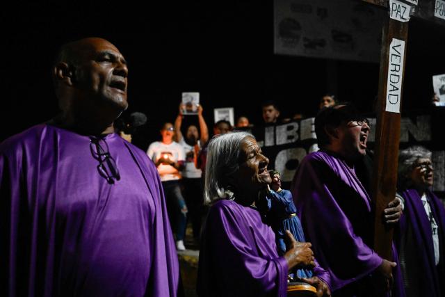 TOPSHOT - Catholic faithful and relatives of political prisoners take part in a procession outside El Rodeo prison during Holy Week in Guatire, Miranda state, Venezuela on April 1, 2026. (Photo by Maryorin Mendez / AFP)