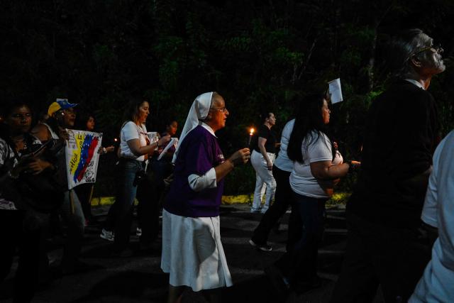 Catholic faithful and relatives of political prisoners take part in a procession outside El Rodeo prison during Holy Week in Guatire, Miranda state, Venezuela on April 1, 2026. (Photo by Maryorin Mendez / AFP)