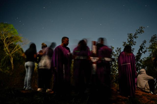 Catholic faithful and relatives of political prisoners take part in a procession outside El Rodeo prison during Holy Week in Guatire, Miranda state, Venezuela on April 1, 2026. (Photo by Maryorin Mendez / AFP)
