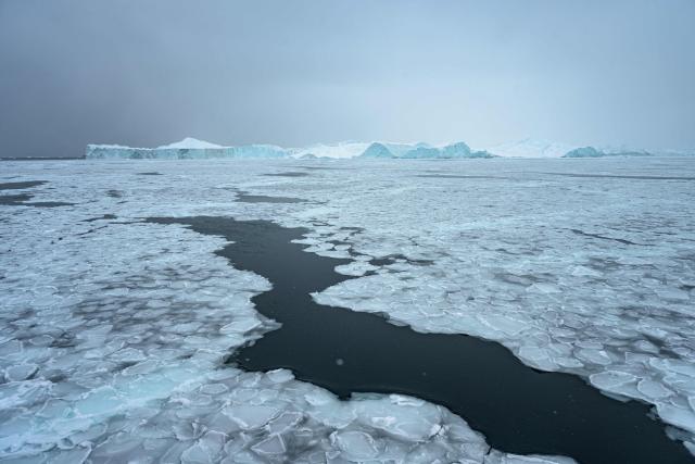 This photograph shows sea ice forming around icebergs in Disko Bay, not far from Ilulissat, Greenland, on March 15, 2026. The Sarfaq Ittuk is a vital and iconic coastal ferry for Greenlanders, keeping small west coast communities connected to low cost. It links Qaqortoq in the south to Ilulissat in the north in a week-long journey. This year, an unusually warm January allowed the ferry to reach Ilulissat much earlier than usual, as the town is normally blocked by sea ice in March. Around 200 passengers travel on board for medical needs, work, tourism, or simply to meet people. But with new airports opening and a lack of investors, the future of the Sarfaq Ittuk is increasingly uncertain. (Photo by Florent VERGNES / AFP)
