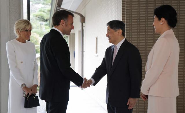 France's President Emmanuel Macron (2nd-L) shakes hands with Japan's Emperor Naruhito (2nd-R) as First Lady Brigitte Macron (L) and Empress Masako look on at the Imperial Palace in Tokyo on April 2, 2026. (Photo by Ludovic MARIN / POOL / AFP)