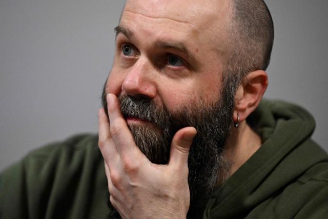 The frontman of the Ukrainian metal band "1914" Dmytro Ternushchak, with the stage name "Kumar", speaks with AFP journalists prior to their concert at the Proxima music club in Warsaw on March 25, 2026. Like other bands, "1914" is raising money for the Ukrainian army. Kumar is attempting to "open the eyes" of Europeans in light of the Kremlin's warmongering, showing that Ukraine poses as an "eastern shield". Their latest album, released in November 2025, follows the story of a Ukrainian from Galicia in their fight against Russia in the First World War. (Photo by Sergei GAPON / AFP)