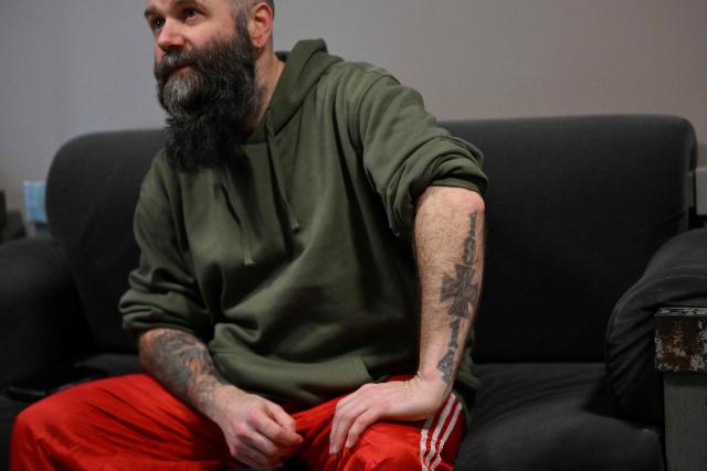 The frontman of the Ukrainian metal band "1914" Dmytro Ternushchak, with the stage name "Kumar", speaks with AFP journalists prior to their concert at the Proxima music club in Warsaw on March 25, 2026. Like other bands, "1914" is raising money for the Ukrainian army. Kumar is attempting to "open the eyes" of Europeans in light of the Kremlin's warmongering, showing that Ukraine poses as an "eastern shield". Their latest album, released in November 2025, follows the story of a Ukrainian from Galicia in their fight against Russia in the First World War. (Photo by Sergei GAPON / AFP)