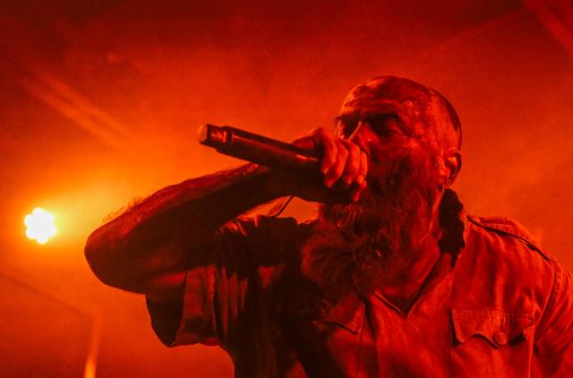 The frontman of the Ukrainian metal band "1914" Dmytro Ternushchak, with the stage name "Kumar", performs on stage during a concert at the Proxima music club in Warsaw on March 25, 2026. Like other bands, "1914" is raising money for the Ukrainian army. Kumar is attempting to "open the eyes" of Europeans in light of the Kremlin's warmongering, showing that Ukraine poses as an "eastern shield". Their latest album, released in November 2025, follows the story of a Ukrainian from Galicia in their fight against Russia in the First World War. (Photo by Sergei GAPON / AFP)