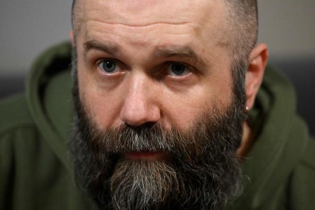 The frontman of the Ukrainian metal band "1914" Dmytro Ternushchak, with the stage name "Kumar", speaks with AFP journalists prior to their concert at the Proxima music club in Warsaw on March 25, 2026. Like other bands, "1914" is raising money for the Ukrainian army. Kumar is attempting to "open the eyes" of Europeans in light of the Kremlin's warmongering, showing that Ukraine poses as an "eastern shield". Their latest album, released in November 2025, follows the story of a Ukrainian from Galicia in their fight against Russia in the First World War. (Photo by Sergei GAPON / AFP)