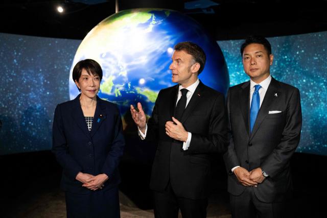 French President Emmanuel Macron (C) visits the company Astroscale, accompanied by Japanese Prime Minister Sanae Takaichi and Nobu Okada, founder and CEO at Astroscale, in Tokyo on April 2, 2026. (Photo by Jeanne ACCORSINI / POOL / AFP)
