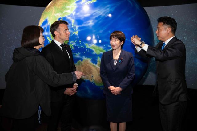 French President Emmanuel Macron (2nd-L) visits the company Astroscale, accompanied by Japanese Prime Minister Sanae Takaichi and Nobu Okada, founder and CEO at Astroscale, in Tokyo on April 2, 2026. (Photo by Jeanne ACCORSINI / POOL / AFP)