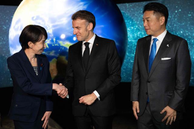 French President Emmanuel Macron (C) visits the company Astroscale, accompanied by Japanese Prime Minister Sanae Takaichi and Nobu Okada, founder and CEO at Astroscale, in Tokyo on April 2, 2026. (Photo by Jeanne ACCORSINI / POOL / AFP)