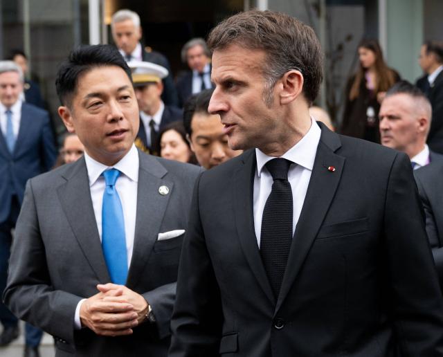 French President Emmanuel Macron (R) and Nobu Okada (L), founder and CEO at Astroscale, leave after a visit to Astroscale, a space venture company, in Tokyo on April 2, 2026. (Photo by Jeanne ACCORSINI / POOL / AFP)