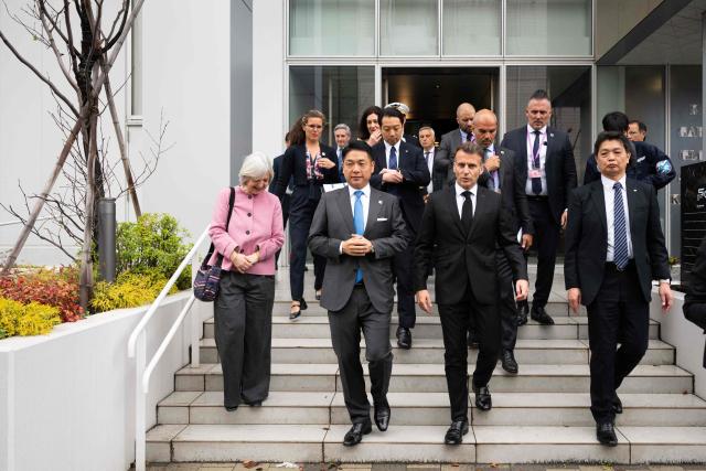 French President Emmanuel Macron (2nd-R) and Nobu Okada (2nd-L), founder and CEO at Astroscale, leave after a visit to Astroscale, a space venture company, in Tokyo on April 2, 2026. (Photo by Jeanne ACCORSINI / POOL / AFP)