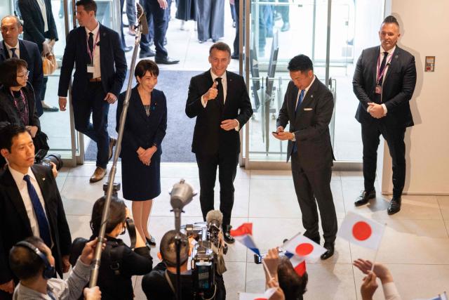 French President Emmanuel Macron (C) speaks to the press during a visit to Astroscale, accompanied by Japanese Prime Minister Sanae Takaichi (center-L) and Nobu Okada (center-R), founder and CEO at Astroscale, in Tokyo on April 2, 2026. (Photo by Jeanne ACCORSINI / POOL / AFP)
