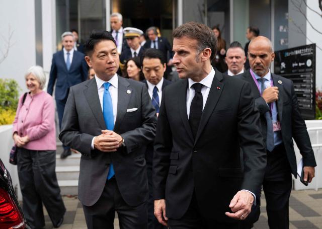 French President Emmanuel Macron (2nd-R) and Nobu Okada (2nd-L), founder and CEO at Astroscale, leave after a visit to Astroscale, a space venture company, in Tokyo on April 2, 2026. (Photo by Jeanne ACCORSINI / POOL / AFP)