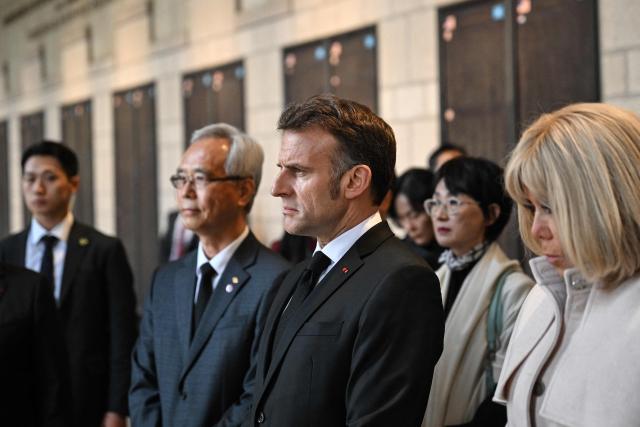French President Emmanuel Macron and his wife Brigitte Macron (R) look at a monument with the names of fallen French soldiers who fought for South Korea during the 1950-53 Korean War, during a visit at the War Memorial of Korea in Seoul on April 2, 2026. (Photo by JUNG Yeon-je / AFP)