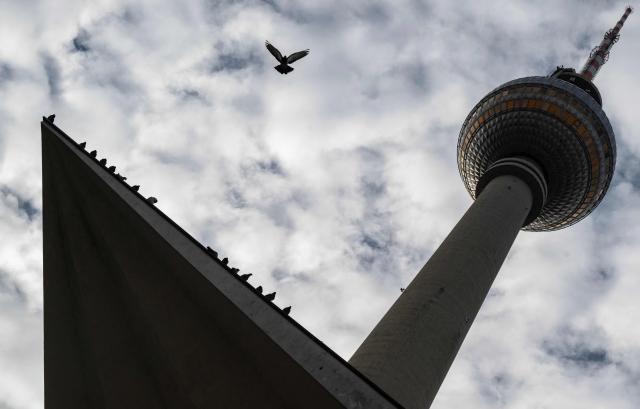 A bird sitting on a ledge under Berlin's landmark TV tower takes flight on April 2, 2026. (Photo by John MACDOUGALL / AFP)