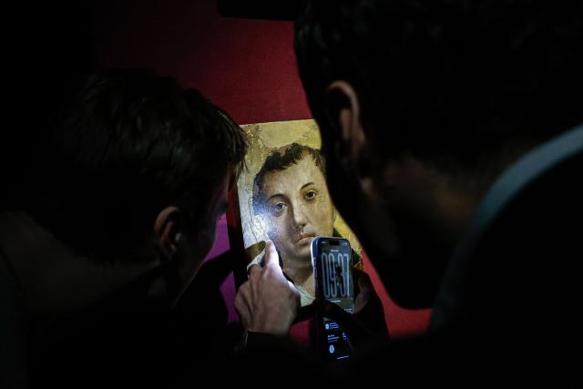 Two employees look at a painting entitled "Face of a Young Saint" by artist Antonello da Messina ahead of its auction at Hotel Drouot auction house in Paris on April 2, 2026. (Photo by STEPHANE DE SAKUTIN / AFP)