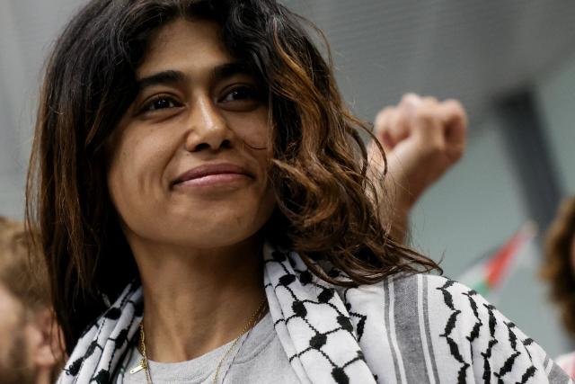 (FILES) French-Palestinian lawyer and member of European Parliament for La France Insoumise (LFI) party Rima Hassan, who was sailing aboard vessels from the Gaza-bound aid flotilla before being stopped and detained by Israeli forces, looks on as she is greeted by a crowd of supporters at the arrivals area of Orly airport, in the outskirts of Paris, on October 7, 2025. French-Palestinian lawyer and member of European Parliament for La France Insoumise (LFI) party Rima Hassan was taken into police custody, France's far-left La France Insoumise - LFI party sources announced on April 2, 2026. (Photo by Anne-Christine POUJOULAT / AFP)