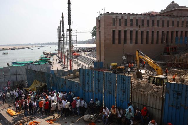 Relatives of the deceased wait for funeral rites near an ongoing construction work at Manikarnika Ghat in Varanasi on April 2, 2026. (Photo by Niharika KULKARNI / AFP)